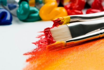 paintbrushes dipped with colourfull paint